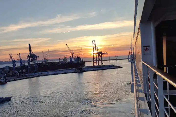 Hafengelände bei Sonnenuntergang auf einem Kreuzfahrtschiff, welches tief in die Nacht schippert und ablegt