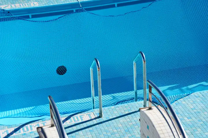 Mit einem Netz abgedeckter Swimmingpool. Symbolbild Wartungsarbeiten und Baustelle am Pool im Urlaub
