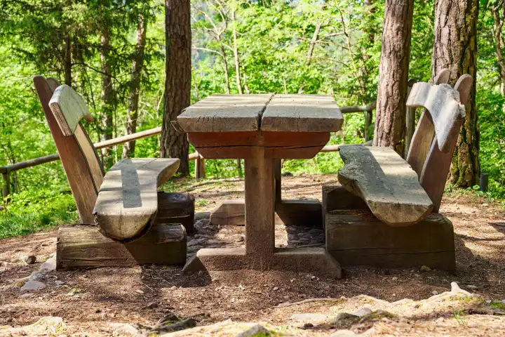 Parkbank bzw. Picknickplatz aus Holz in einem Wald für Wanderer in Tirol