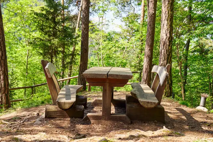 Parkbank bzw. Picknickplatz aus Holz in einem Wald für Wanderer in Tirol