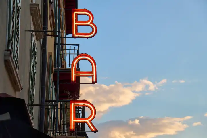 Leuchtschrift: Bar, an einem gebäude bei Sonnenuntergang