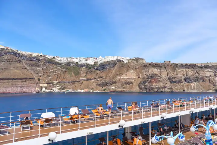 Kreuzfahrt Themenbild, ein Kreuzfahrtschiff mit Urlaubern vor der Insel Santorini in Griechenland