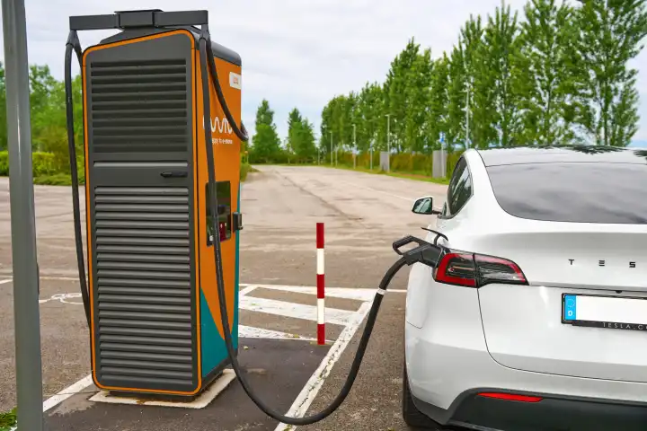 Ewiva Ladestation für Elektro Fahrzeuge. Ein Tesla Model Y lädt Strom an einer Schnellladesäule von Ewiva in Italien