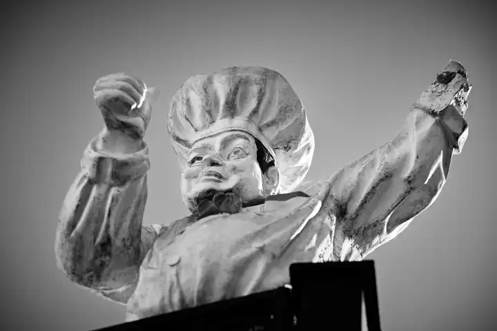 Defekte Figur von einem Koch mit einem Arm. Schwarz Weiß Bild. Symbolbild Gastronomie Krise