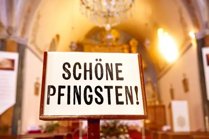Schöne Pfingsten! Pfingstgrüße, Schriftzug auf einem Schild vor einem Altar in der Kirche. FOTOMONTAGE