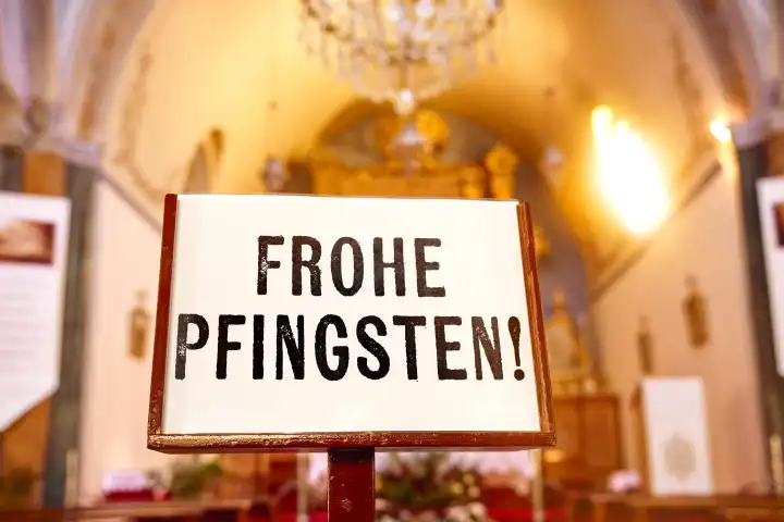 Frohe Pfingsten! Pfingstgrüße, Schriftzug auf einem Schild vor einem Altar in der Kirche. FOTOMONTAGE