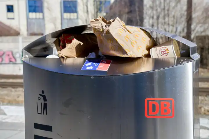 Überfüllter Mülleimer an einem Bahnhof der Deutschen Bahn