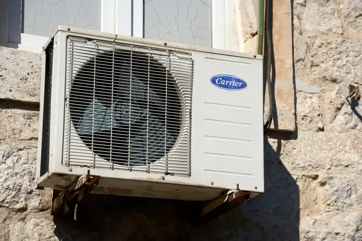 Ein Außengerät einer Klimaanlage an der Fassade von einem Wohnhaus. Klimagerät der Marke Carrier