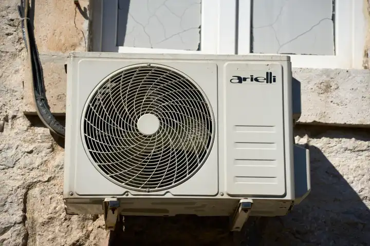 Ein Außengerät einer Klimaanlage an der Fassade von einem Wohnhaus. Klimagerät der Marke arielli