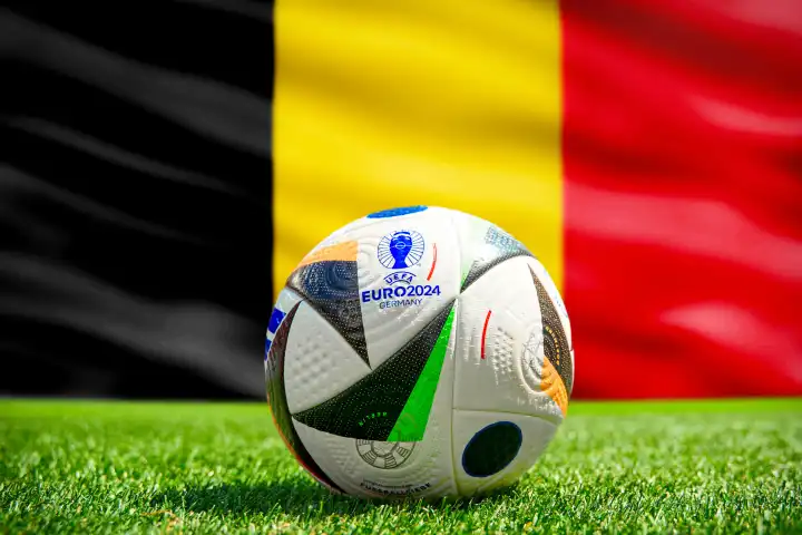 Fußball Europameisterschaft UEFA EURO 2024 in Deutschland: Offizieller Spielball von Adidas auf dem Spielfeld mit Nationalflagge von Belgien. FOTOMONTAGE