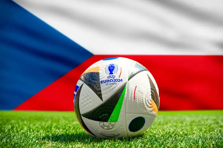 Fußball Europameisterschaft UEFA EURO 2024 in Deutschland: Offizieller Spielball von Adidas auf dem Spielfeld mit Nationalflagge von Tschechien. FOTOMONTAGE