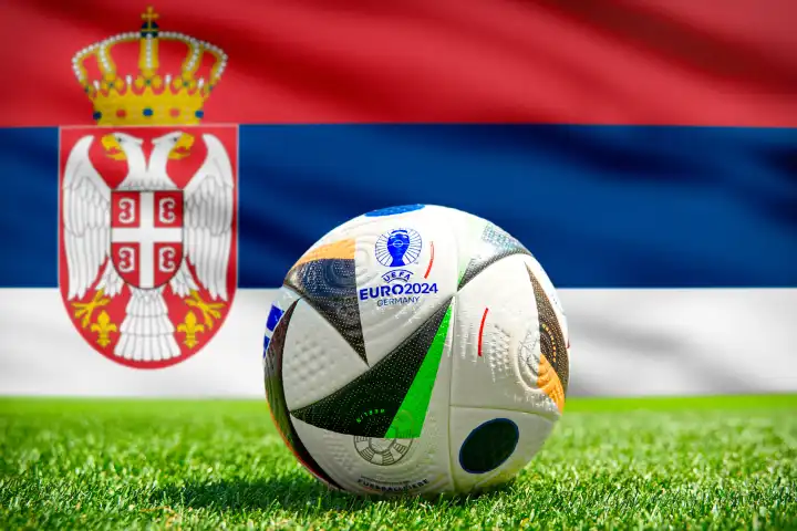 Fußball Europameisterschaft UEFA EURO 2024 in Deutschland: Offizieller Spielball von Adidas auf dem Spielfeld mit Nationalflagge von Serbien. FOTOMONTAGE