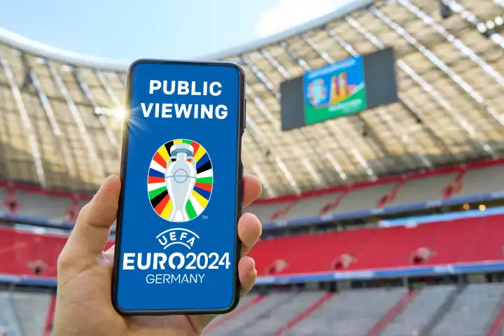 Public Viewing München, zur UEFA EURO 2024, bzw. Fußball-Europameisterschaft 2024. Smartphone, bzw. Handy mit offiziellem Logo im Fußball-Stadion Allianz Arena. FOTOMONTAGE