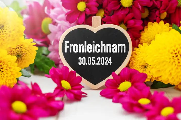Herz mit Aufschrift: Fronleichnam, 30 Mai 2024, umgeben von bunten Blumen. FOTOMONTAGE