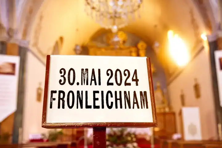 Fronleichnam, Schriftzug auf einem Schild in einer Kirche. Katholischer Feiertag am 30 Mai 2024. FOTOMONTAGE