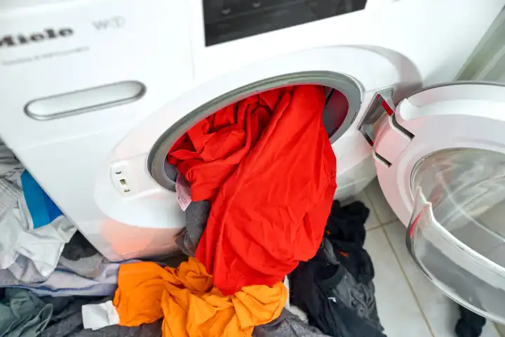 Waschmaschinen-Trommel voll Wäsche nach einer Reise, Konzept Beladung und Wäscheberge nach dem Urlaub