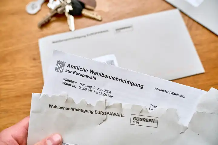 Wähler öffnet einen Brief mit der Amtlichen Wahlbenachrichtigung für die Wahlunterlagen zur Europawahl 2024 in Deutschland