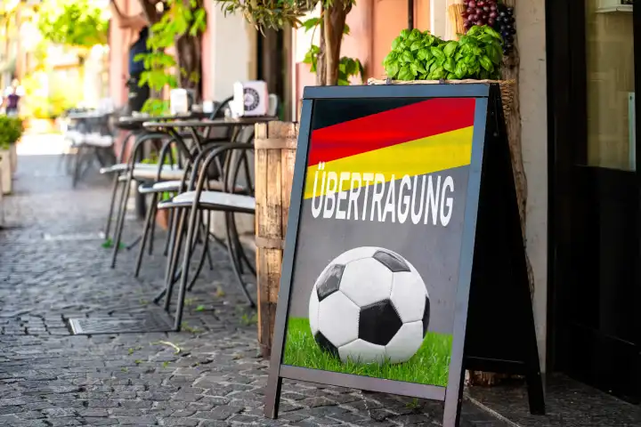 Übertragung, Schriftzug mit Deutschlandflagge auf einem Schild vor einem Gastronomiebetrieb. Symbolbild Public Viewing der Fußball Europameisterschaft 2024. FOTOMONTAGE