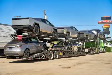 Auslieferung des neuen Tesla Cybertruck, gepanzerter Pickup als Elektroauto. Elon Musk neues E-Auto, Neuwagen auf einem Transporter in den USA