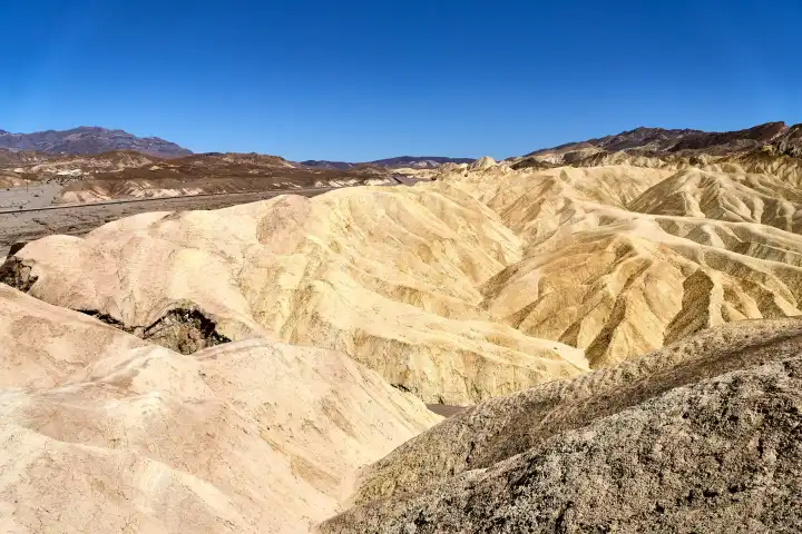 Blick auf die beeindruckenden Felsformationen am Zabriskie Point im Death Valley Nationalpark, Kalifornien, USA. Die Landschaft ist geprägt von extremer Trockenheit und Hitze