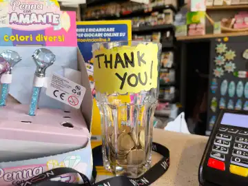 Kaffeekasse mit Wort "Danke" - Thank you, in einem Geschäft, damit der Kunde seinen Dank mit einem Trinkgeld und Münzen aussprechen kann.