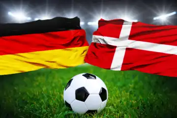 Fußball Europameisterschaft Länderspiel im Achtelfinale Deutschland Dänemark. Ein Fußball auf dem Spielfeld vor der deutschen und dänischen Flagge. FOTOMONTAGE