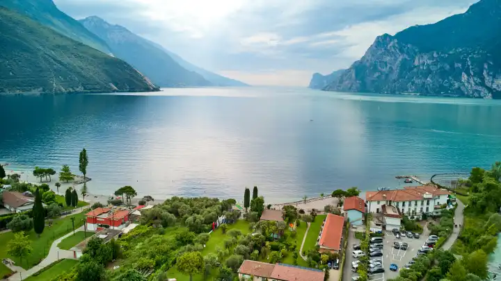 Torbole, Lake Garda, Italy - June 25, 2024: Surfer's paradise Torbole on Lake Garda from above with a beautiful mountain backdrop and bright blue water. Torbole attracts athletes and tourists such as sailors, surfers and windsurfers every year.