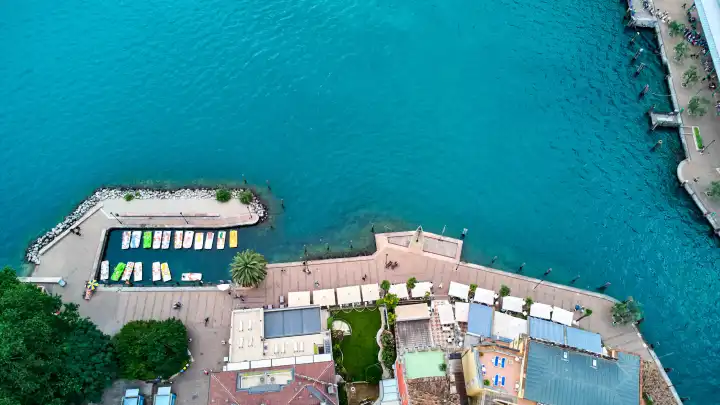  Tretboote bzw. Tretbootvermietung von oben in Riva del Garda. Hier können sich Touristen Boote für Studen auf dem Gardasee ausleihen und auf dem See paddeln.