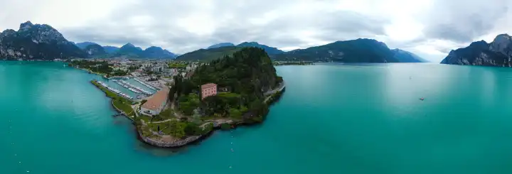 Torbole, Lake Garda, Italy - June 24, 2024: Panorama shot with a drone of Lake Garda in a beautiful mountain scenery between the municipality of Nago-Torbole and Riva. Bright blue water and many trees.