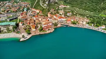 Nago Torbole, Lake Garda, Italy - June 26, 2024: Aerial view of the northern village of Torbole on Lake Garda in Italy, surrounded by the majestic Alps