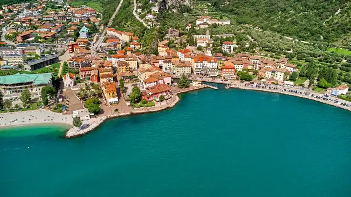 Nago Torbole, Lake Garda, Italy - June 26, 2024: Aerial view of the northern village of Torbole on Lake Garda in Italy, surrounded by the majestic Alps