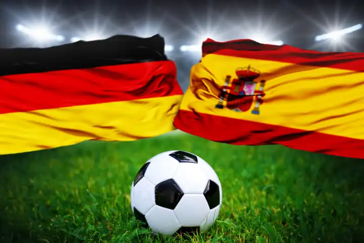 Fußball Europameisterschaft Länderspiel im Viertelfinale Deutschland Spanien. Ein Fußball auf dem Spielfeld vor der deutschen und spanischen Flagge. FOTOMONTAGE