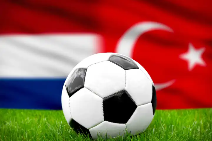 Fußball Europameisterschaft Länderspiel im Viertelfinale Niederlande Türkei. Ein Fußball auf dem Spielfeld vor der niederländischer und türkischer Flagge. FOTOMONTAGE