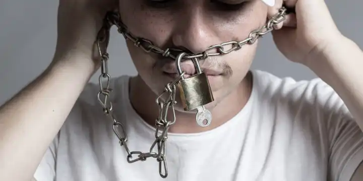 Teen Covered Mouth by Rusty Chain and Lock to Forbidden Him the Free Speeching Isolated on Grey Background