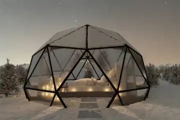 Geodesic dome hut with glass panels on a winter's night