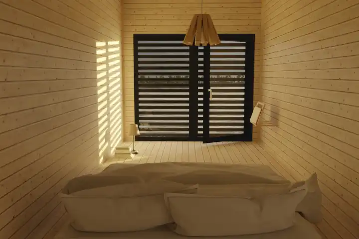 Schlafzimmer mit Holzdielen und Fenster im Abendsonnenlicht