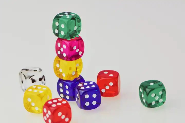 Pile of colored transparent dice against white background