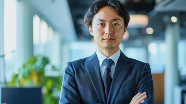 Japanischer Business-Manager im Anzug vor einem unscharfen Büro