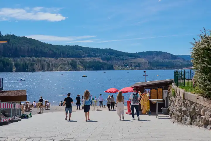 Titisee, Germany - April 06, 2024: Tourists visiting the Titisee. The Titisee is a charming lake located in the southern Black Forest in Baden-Württemberg, Germany.