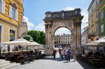 Pula, Istrien, Kroatien - 23. Mai 2024: Touristen am Triumphbogen der Sergier, dem antiken römischen Erbe von Pula, Kroatien