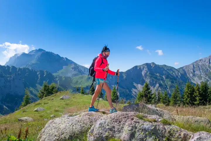 A woman walks in the mountains with anti virus mask