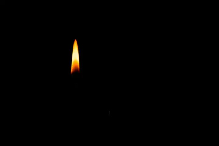 Nahaufnahme einer Kerzenflamme auf schwarzem Hintergrund