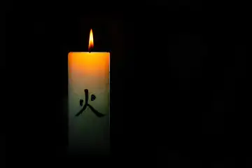 Japanische bunte brennende Kerze auf schwarzem Hintergrund