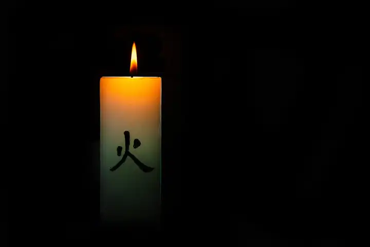 Japanese colorful burning candle on black background
