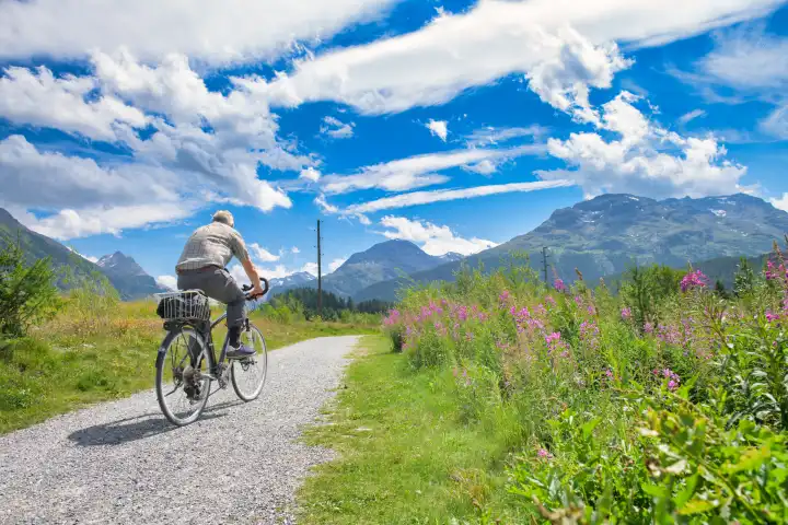 Ein Mann reift während einer Fahrradtour in den Bergen
