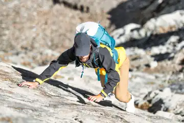 A man tackles a rock passage in the mountains