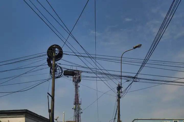 Gewirr von Strom- und Telefonkabeln zwischen Masten in Städten Südamerikas