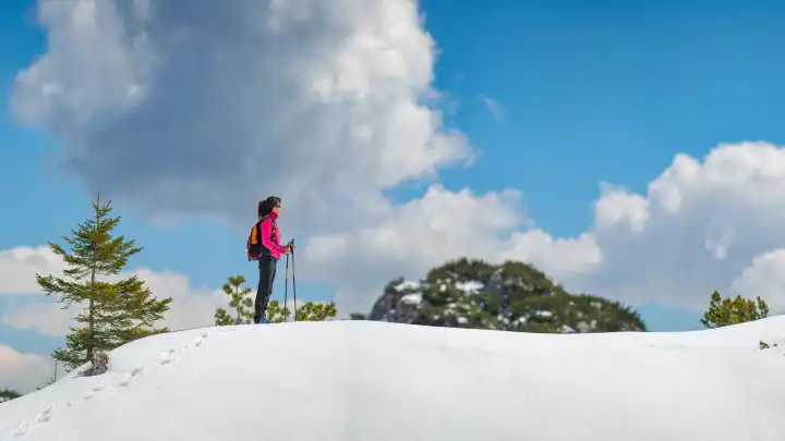 Einsames Mädchen wandert in den Bergen auf dem Schnee