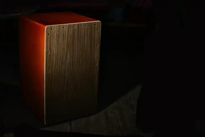 A cajon percussive musical instrument on a black background