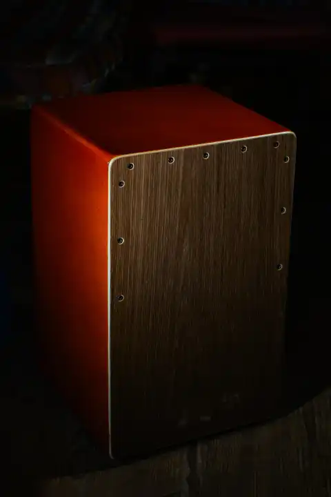 A cajon percussive musical instrument on a black background